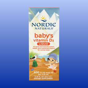 Nordic Naturals Baby's Vitamin D3 Liquid dietary supplement box, featuring a colorful cartoon illustration of a child and a seagull on a beach, set against a blue gradient background.