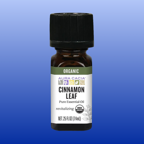 Bottle of Aura Cacia Organic Cinnamon Leaf Pure Essential Oil 0.25 oz with black cap on blue background
