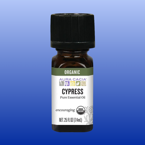 Bottle of Aura Cacia Cypress Organic Essential Oil 0.25 oz with USDA organic label on blue background