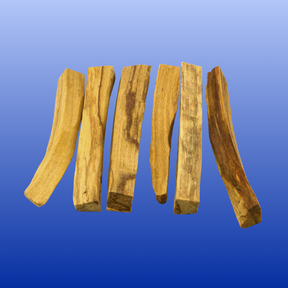 Six natural Palo Santo wood sticks arranged on a blue gradient background for incense and smudging.