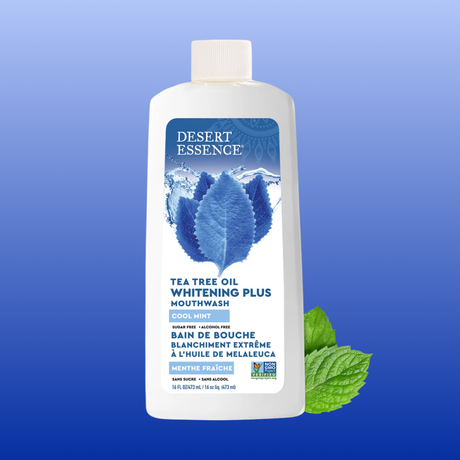 Bottle of Desert Essence Tea Tree Oil Whitening Plus Mouthwash on a blue background