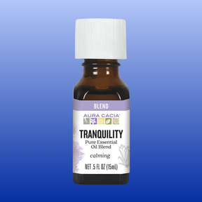 Amber glass bottle of Tranquility essential oil blend by Aura Cacia with white cap and calming lavender label