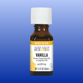 Bottle of Aura Cacia Vanilla Pure Essential Oil in Jojoba Oil 0.5 fl oz with ready-to-use label on blue background